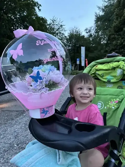 Kind mit Bubble-Ballon zum Geburtstag