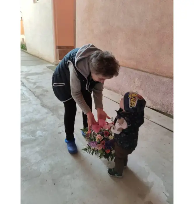 Übergabe eines Blumenstraußes an ein Kind